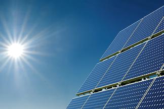 PV-Modul mit Himmel  und Sonne im Hintergrund